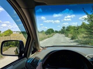 Naklejka premium inside the car. driver behind the wheel. drive a car. journey. bad roads. by car . steering wheel and dashboard. wheels and engine.