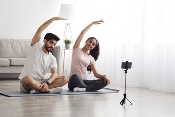 Covid-19 pandemic, lessons online, trainer remotely. Millennial happy arab male and lady in lotus...