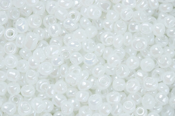 Pile of small shiny pearl white beads for background. Top view