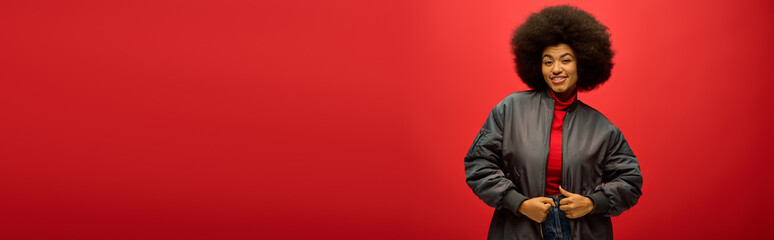 Stylish young woman with a confident smile against a vibrant red backdrop