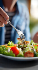 A close-up of a person enjoying a fresh salad, with vibrant greens and colorful vegetables, showcasing healthy eating habits and culinary delight.