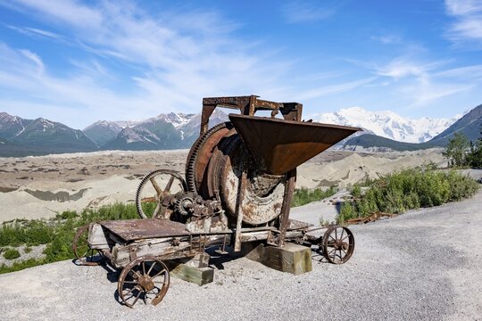 Old rusted moving mill for rock in front of mountain landscape with Kennicott Glacier, Historic Kennecott Copper Mine, National Historic Landmark, Wrangell St. Elias National Park, Alaska, USA
