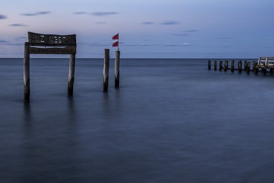 Wooden sign in the sea with inscription Zingst and Buhnen, long exposure, evening light, Zingst, Fischland-Dar&szlig;-Zingst, Western Pomerania National Park, Mecklenburg-Western Pomerania, Germany
