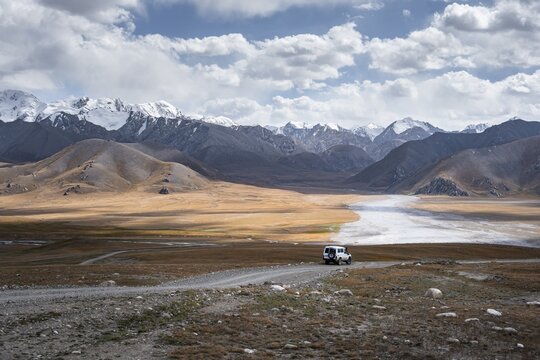 Off-road vehicle on a gravel track, glaciated and snow-covered peaks, Ak Shyrak Mountains, near Kumtor, Kara-Say, Tian Shan, Kyrgyzstan