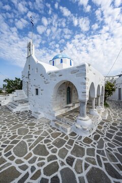 White Greek Orthodox Church Holy Church of Agios Konstantinos with Greek flag, Parikia, Paros, Cyclades, Greece