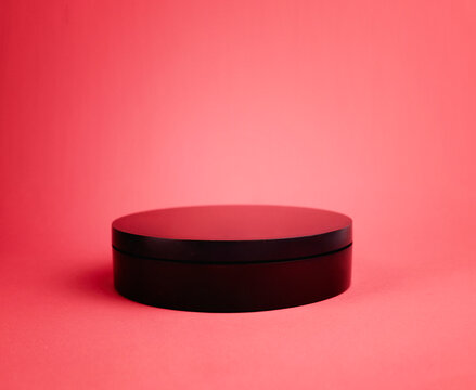 Black round stage on pink red background empty sdvertisement design space.Minimal platform,product display,Valentine's showcase.