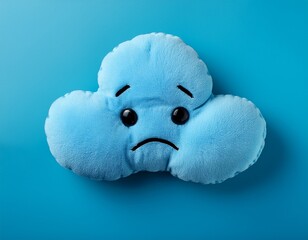 Top view of blue sad plush toy in shape of a cloud on blue background and copy space. Blue  monday concept