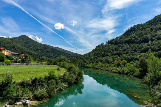 Vista panoramica della valle naturale collinare slovena in cui scorre il fiume Isonzo, di giorno, con cielo parzialmente sereno, in estate