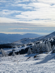 Wide winter mountain panorama with layered ridges and snowy forest in Kopaonik. Scenic depth, natural scale, and peaceful travel mood through expansive alpine terrain and clear atmosphere.