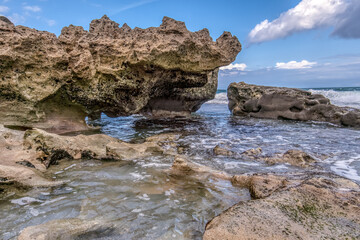 Fototapeta premium A rocky shoreline with a small body of water in between. The water is calm and the sky is clear