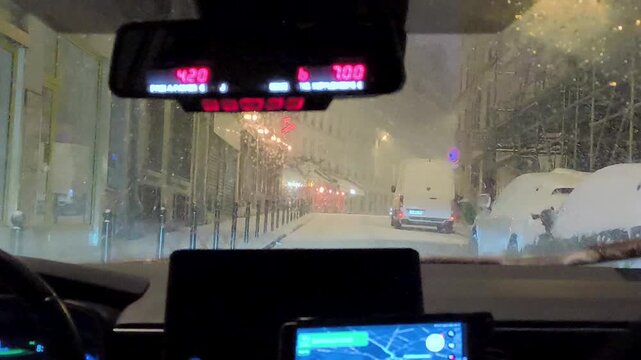 Snowy Paris street seen from car at night