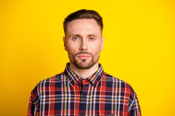 Obraz premium Young man in plaid shirt stands against bright yellow background for lifestyle fashion and advertising use