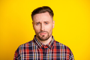 Obraz premium Young man in plaid shirt with thoughtful expression against bright yellow background for fashion lifestyle advertising