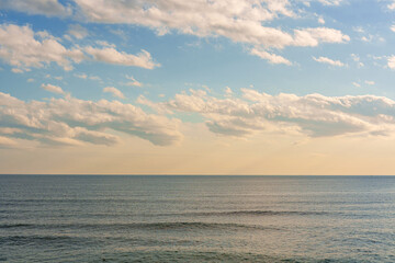 Obraz premium Beautiful summer seascape with clouds and a clear blue sky, background for summer vacation concept.
