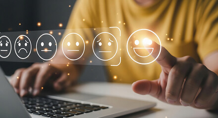 Person selecting a smiling face from a row of emoticons on a laptop screen yellow shirt