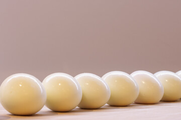 A diagonal row of hard-boiled eggs on a kitchen worktop
