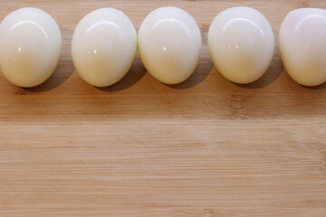 Five boiled eggs on a wooden chopping board