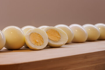 Row of whole and half boiled eggs on a chopping board