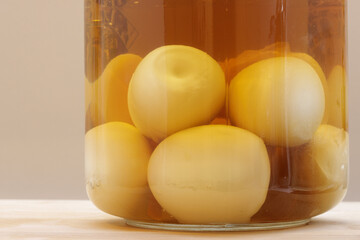 Close up of boiled eggs in bottom of glass pickle jar