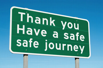 Green road sign with safe journey message
