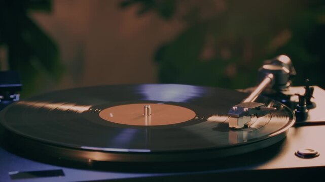 Retro Vinyl record player playing music, close-up macro shot of vintage LP disc old phonograph spinning. Retro music player at home.