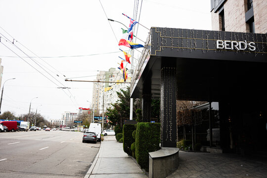 City street scene in Chisinau Moldova with flags and modern BERDS hotel facade at a busy urban avenue