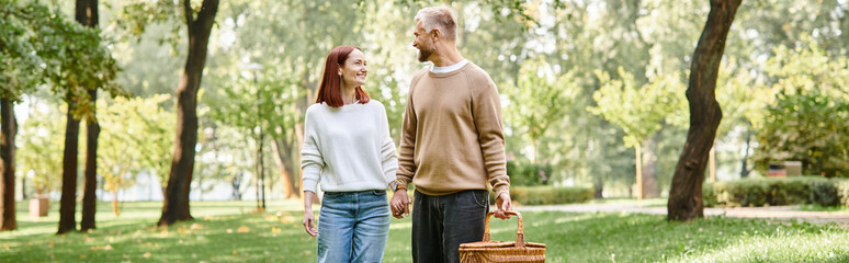 Naklejka premium Couple enjoys a serene spring walk in a lush green park filled with blooming trees