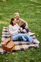 Couple enjoys a spring day in the park with a picnic and love in the air
