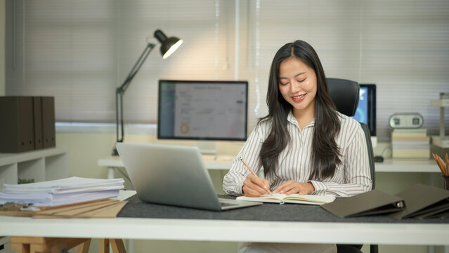 Businesswoman hand working with writing on notebook