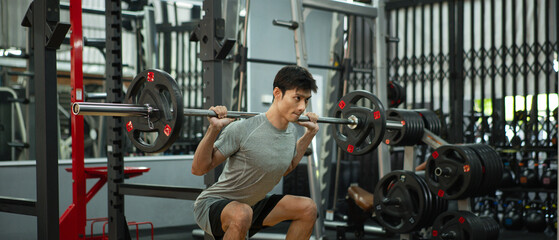 Obraz premium A man doing a squat and lifting weights