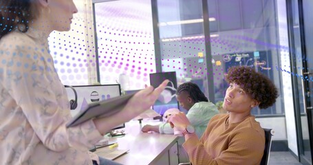 Listening seated male coworker responding at office with tablet, brown sweater, copy space