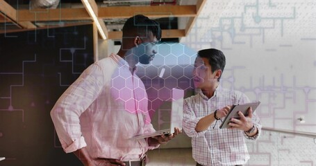 Discussing two coworkers in business shirts holding laptop and tablet stylus in office, hex overlay