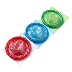 Three colorful red blue green condom foil packets arranged on transparent background