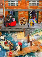 Obraz premium Miniature waterfront warehouse diorama made of plastic construction Lego bricks with forklift and harbor scene: 06.10.2024-Ljubljana, Slovenia.