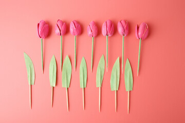 flat lay diy pink tulips made of pistachio shells and paper leaves on coral background. perfect for hobby blogs craft schools art workshops teaching children creative recycling and handmade gifts,