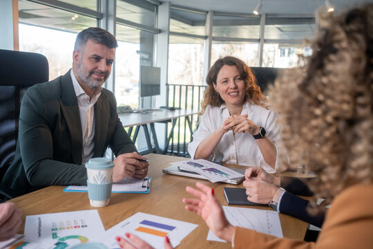 Casual meeting of smiling diverse business team analyzing financial data - Powered by Adobe