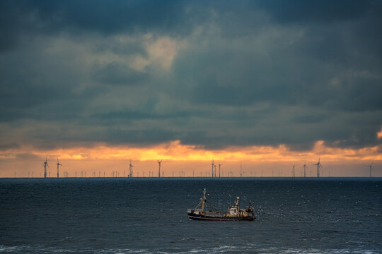 Fishing boat on the North Sea off Egmond aan Zee in the Netherlands at sunset