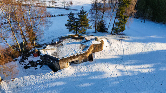 A historic Czechoslovak military bunker (K-S 32 Na ružku) near Lichkov in Orlick&eacute; hory covered by snow in a winter landscape. The abandoned concrete fortification stands among leafless trees and rolli