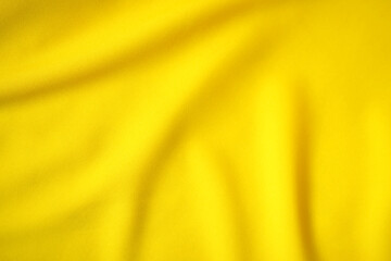 The luxurious and beautiful yellow satin fabric drapes in elegant waves.