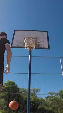 Homem joga basquetebol ao ar livre 
