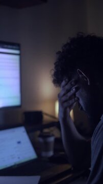 Stressed man experiencing burnout working late at night on computer
