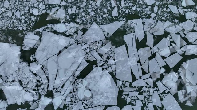 Aerial top view of a winter harbor along a frozen river. Industrial port area and icy shoreline forming calm, graphic winter patterns.