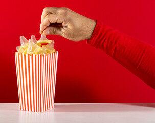 Hand reaching for unusual popcorn in striped box