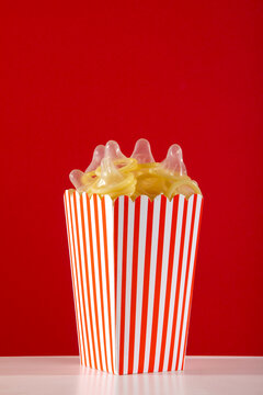 Creative use of condoms in popcorn bucket on red