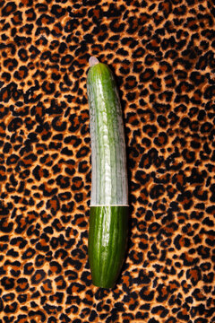 Cucumber with a condom on leopard print background