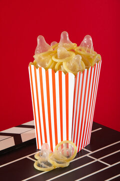Playful mix of popcorn box with condoms in vibrant setting