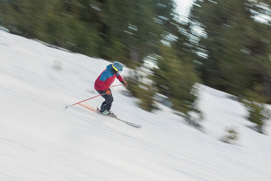 Man skiing rapidly down snowy slope in the Pyrenees
