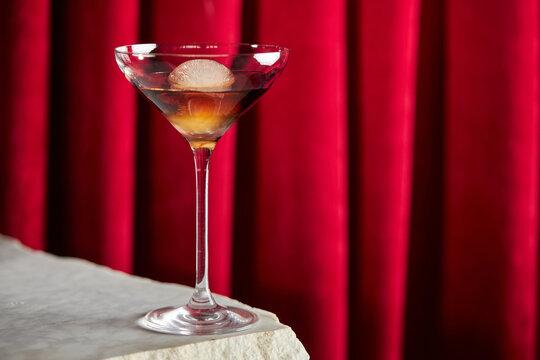 Elegant vermouth cocktail with red curtain backdrop
