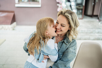 Tender moment: mom and daughter at a cafe street