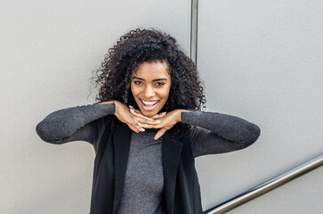 Smiling woman outdoors with her hands on her chin